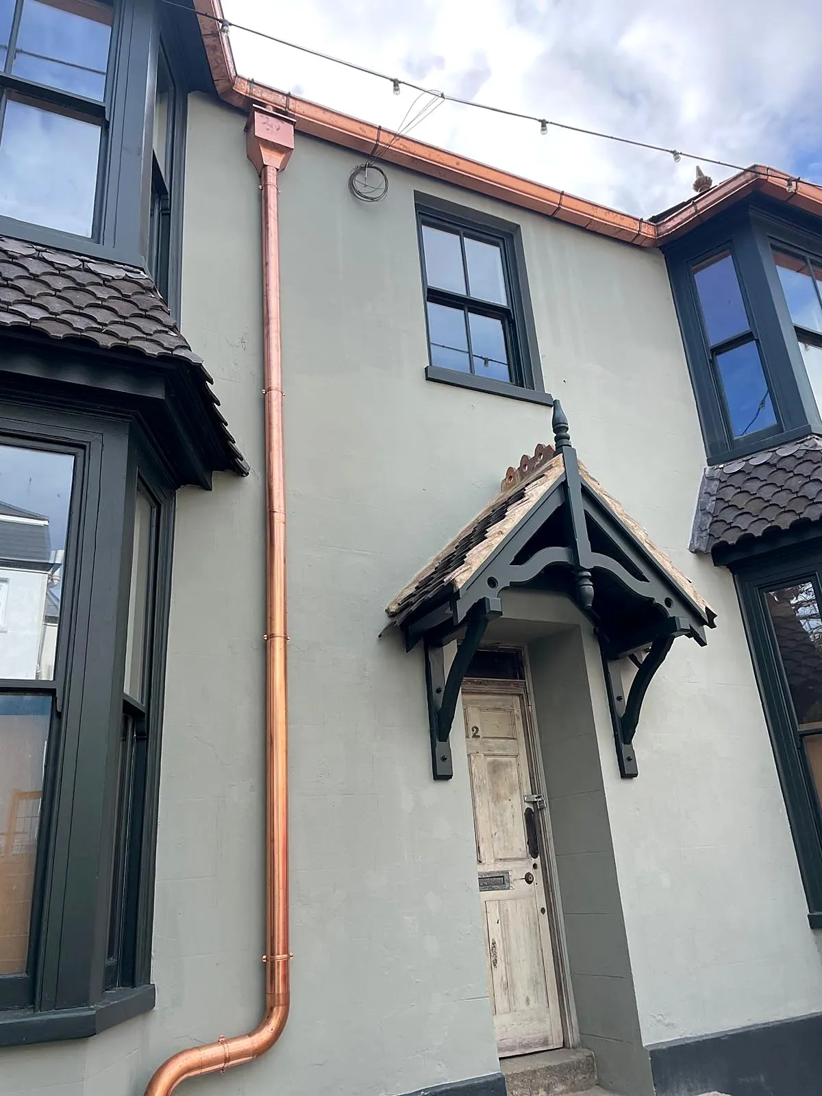 New copper rainwater downpipe and hopper head fitted to a period house