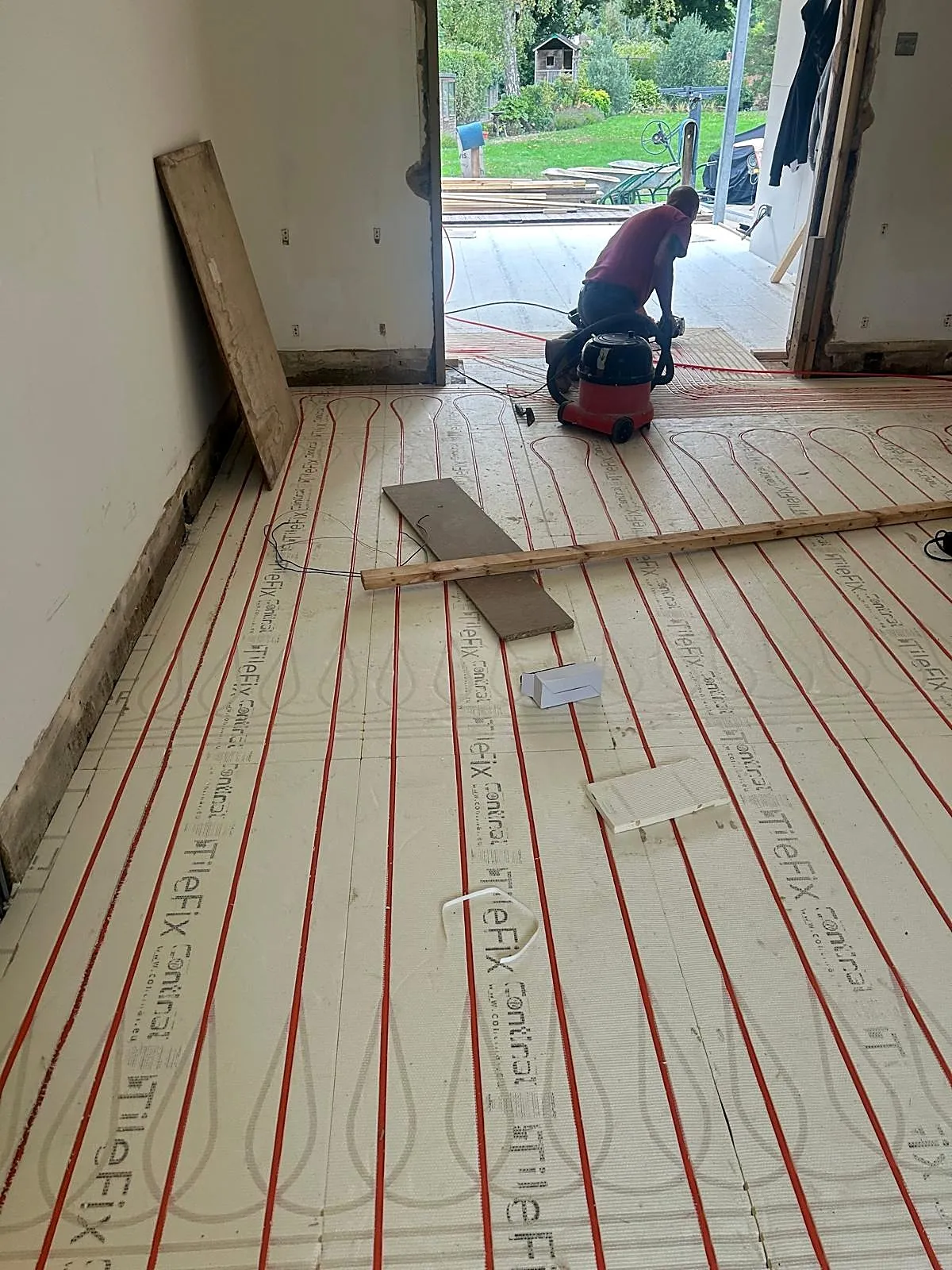 Wet underfloor heating pipes laid in insulation boards during installation, photo 7