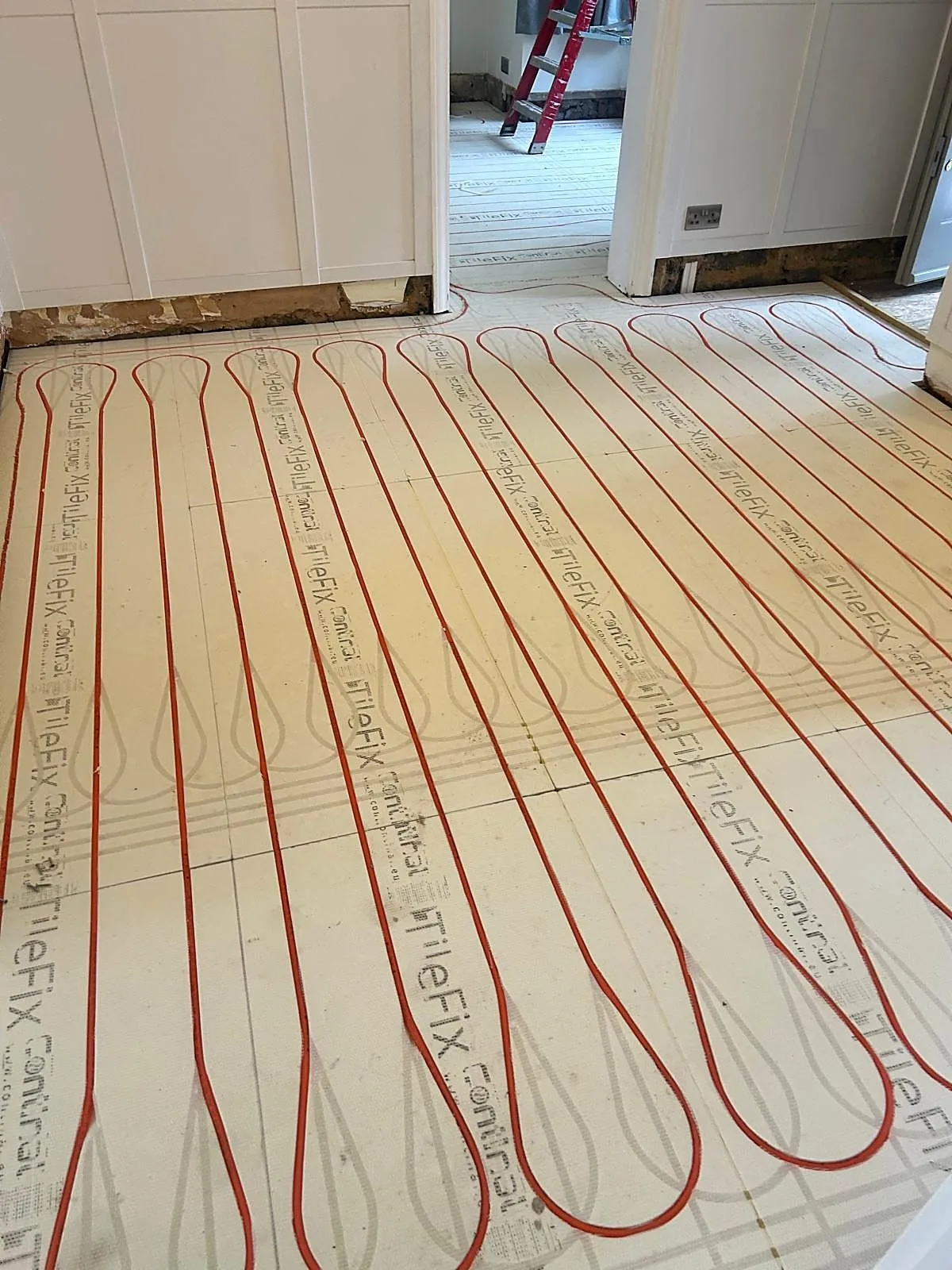 Wet underfloor heating pipes laid in insulation boards during installation, photo 9