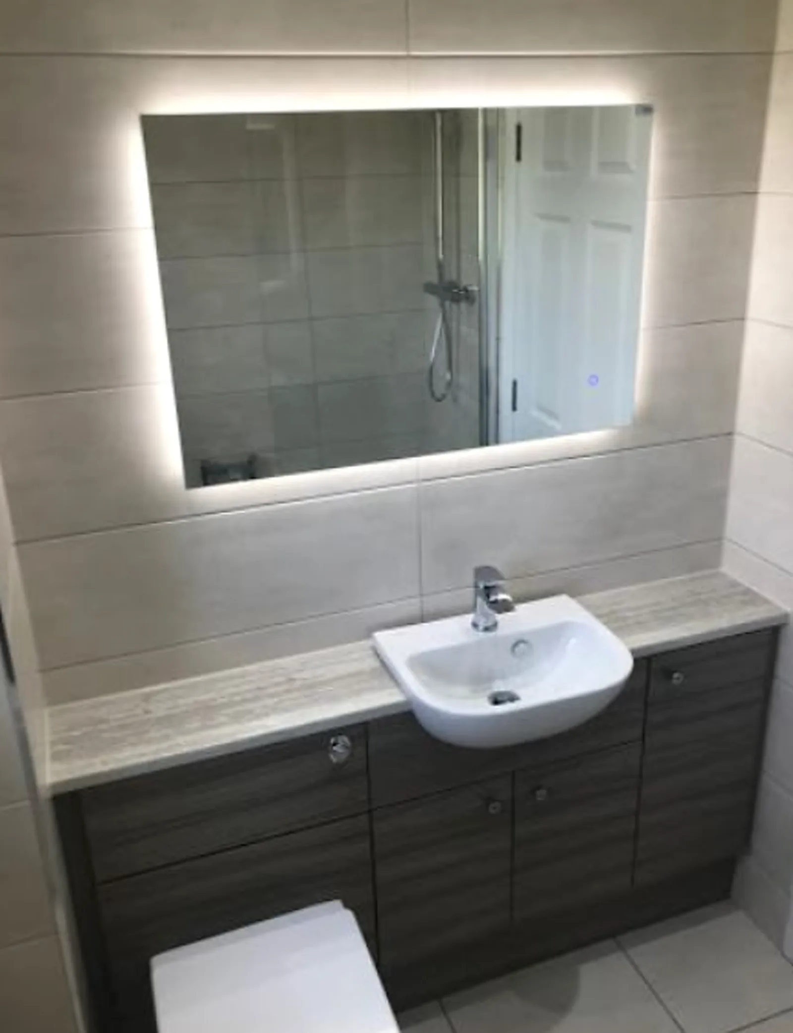 Fitted vanity unit with basin, back-lit mirror and concealed cistern