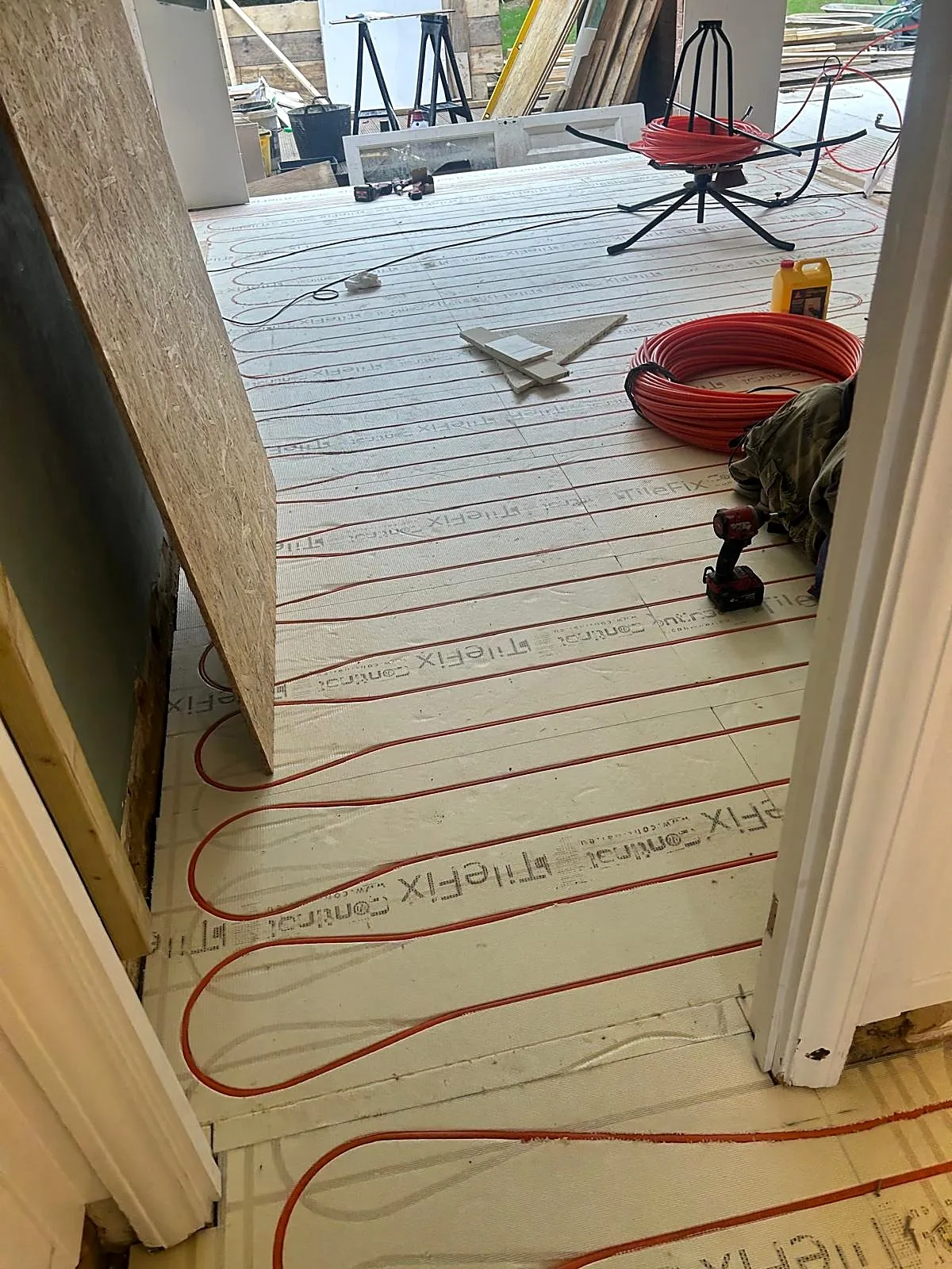 Wet underfloor heating pipes laid in insulation boards during installation, photo 8