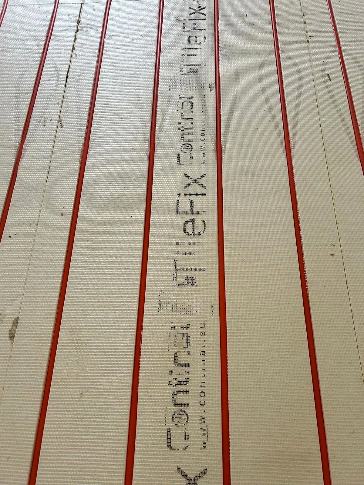 Wet underfloor heating pipes laid in insulation boards during installation, photo 3