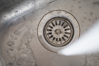 Water flowing into a clear sink drain after drain unblocking