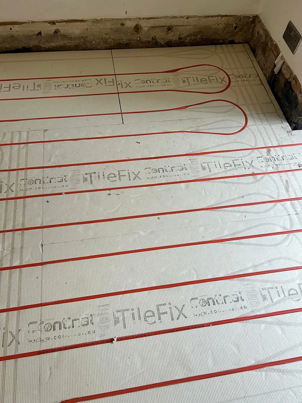 Wet underfloor heating pipes laid in insulation boards during installation, photo 6