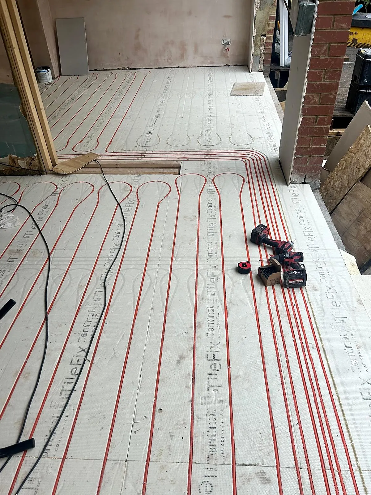 Wet underfloor heating pipes laid in insulation boards during installation, photo 5